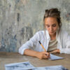 Woman engaging in writing down marketing idea.