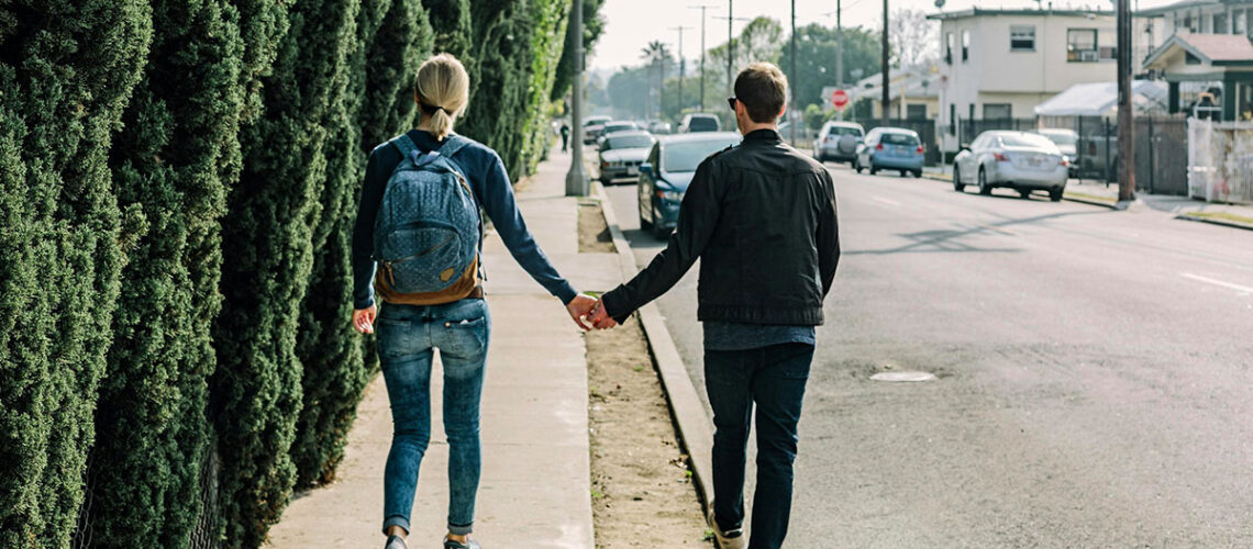 A couple walking down the sidewalk.