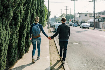 A couple walking down the sidewalk.