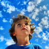 A child gazes up into the sky.