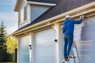 Man painting on a ladder.